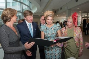 Koning Willem-Alexander en koningin Máxima bekijken het boek Koningsdamast met het essay Van Boom tot Tafel